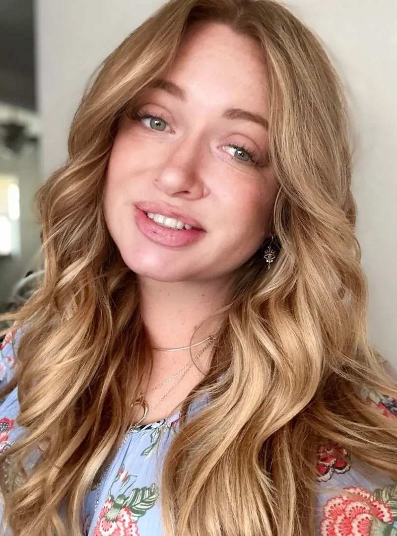 Professional blonde hair stylist working on client's hair in salon